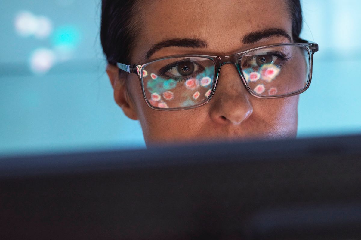 Scientist viewing an electron micrograph of virus particles on a screen (TEK IMAGE/SCIENCE PHOTO LIBRARY / Getty Images)