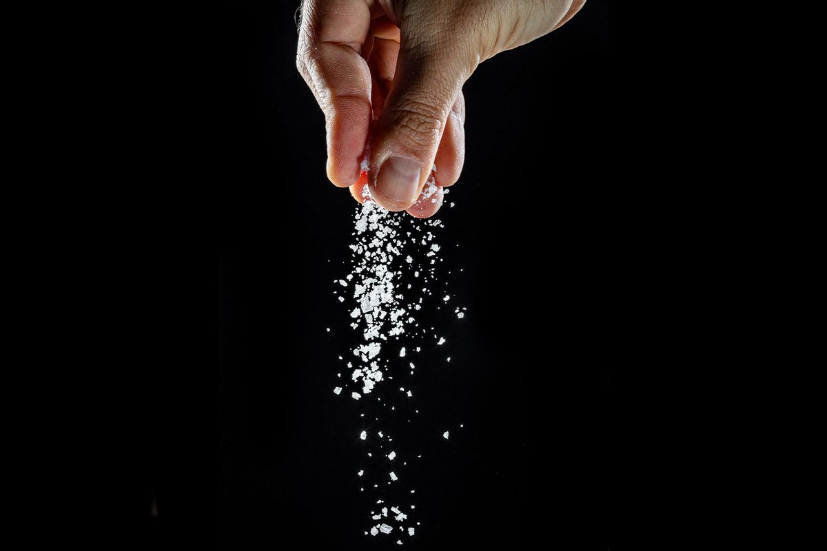 Male hand sprinkling salt (Getty Images/Valentyn Volkov)