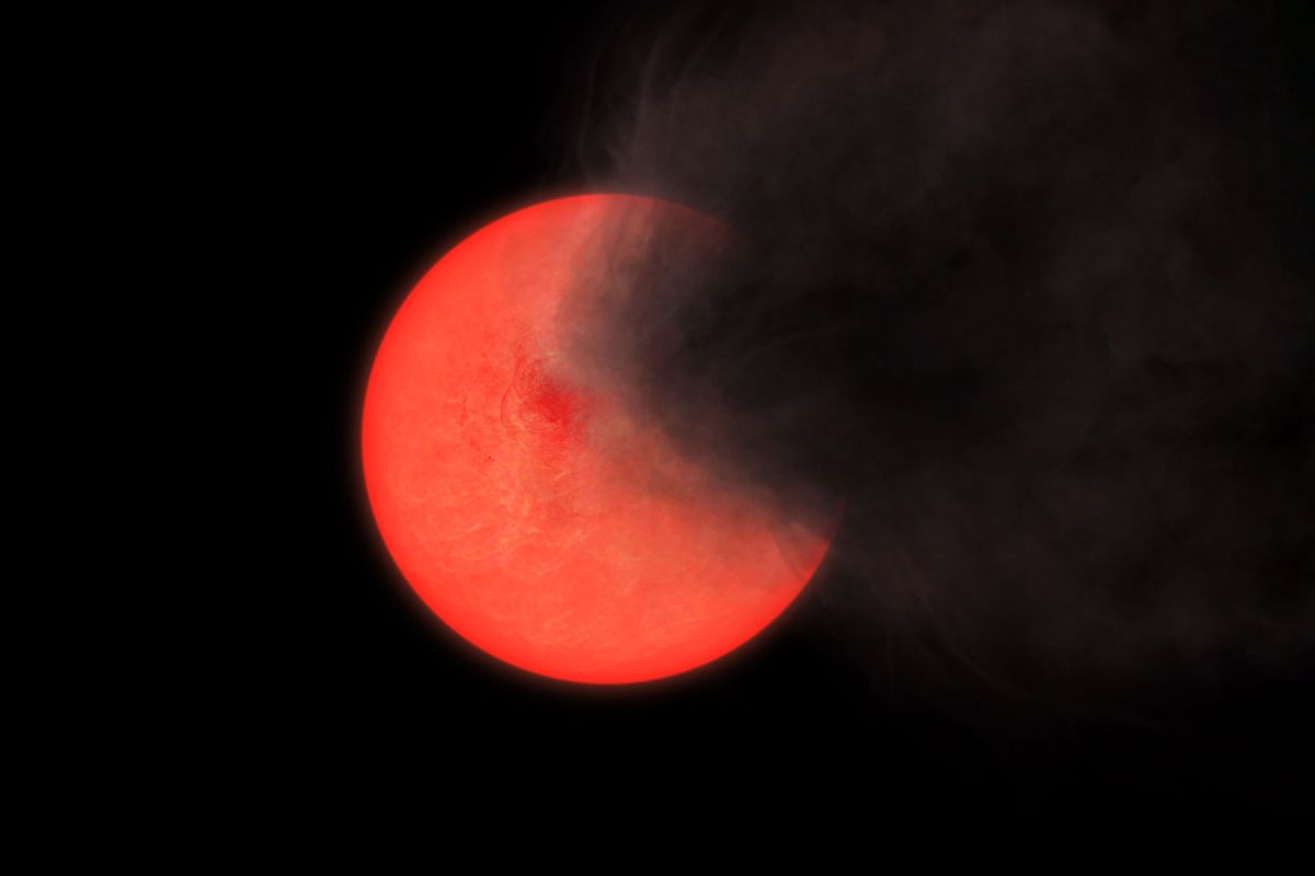 Artist's impression of a cloud of smoke and dust being thrown out by a red giant star. Seen from the left the star remains bright but if viewed from the right it fades to invisibility. (Philip Lucas/University of Hertfordshire)