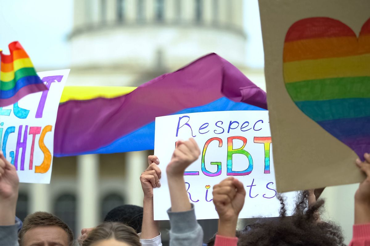 Crowd raising posters to respect LGBT rights (Motortion/Getty Images)