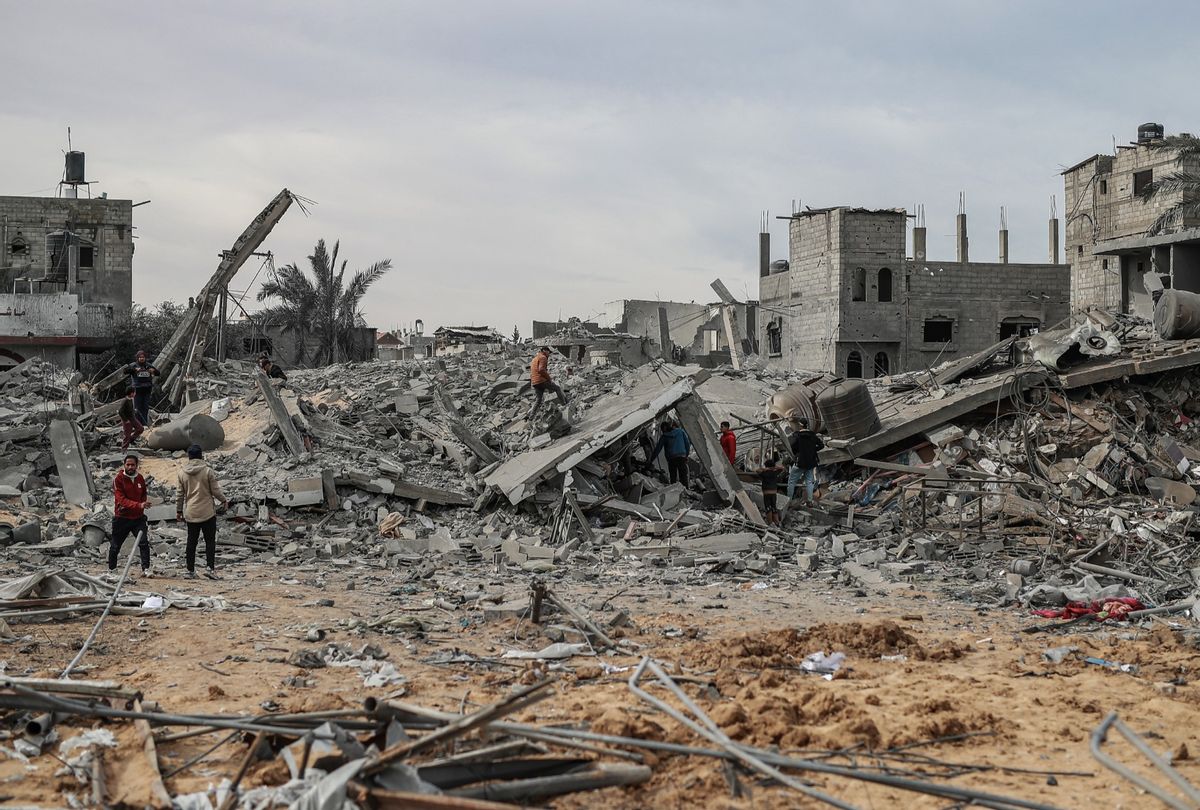 Palestinians, including children, look at the heavily damaged buildings among the rubble after Israeli attacks in Rafah, Gaza on February 12, 2024. B (Jehad Alshrafi/Anadolu via Getty Images)