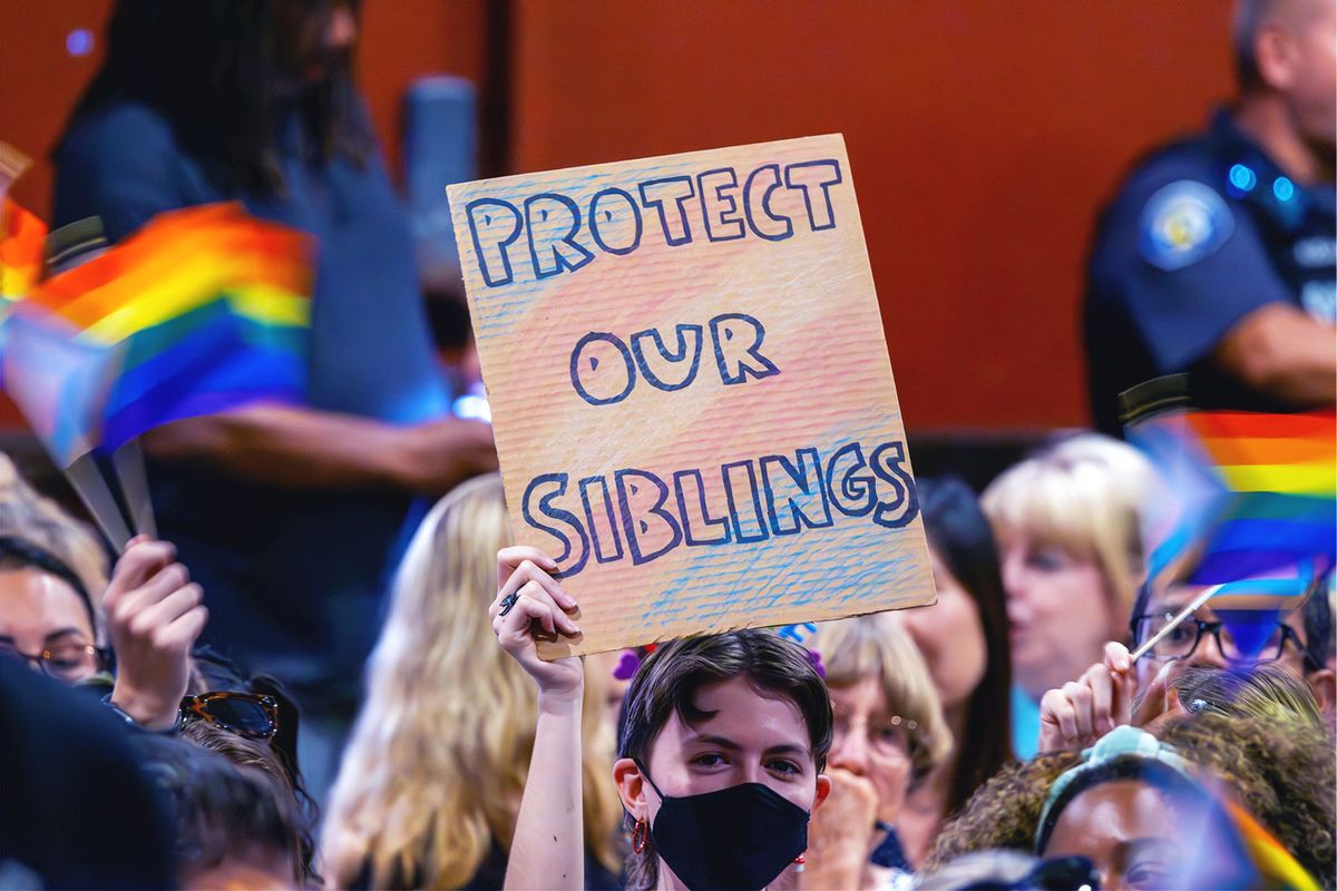 A person holds a sign in opposition to a policy that the Chino Valley school board is meeting to vote on which would require school staff to "out" students to their parents if they ask to be identified by a gender that is not listed on their birth certificate on July 20, 2023 in Chino, California. (David McNew/Getty Images)