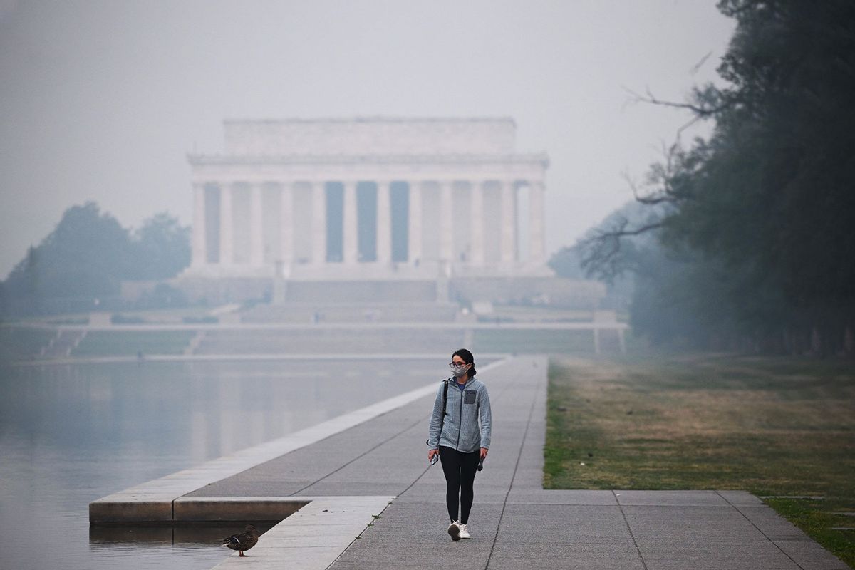 A person walks near the Lincoln Memorial under a blanket of haze in Washington, DC, on June 8, 2023. (MANDEL NGAN/AFP via Getty Images)