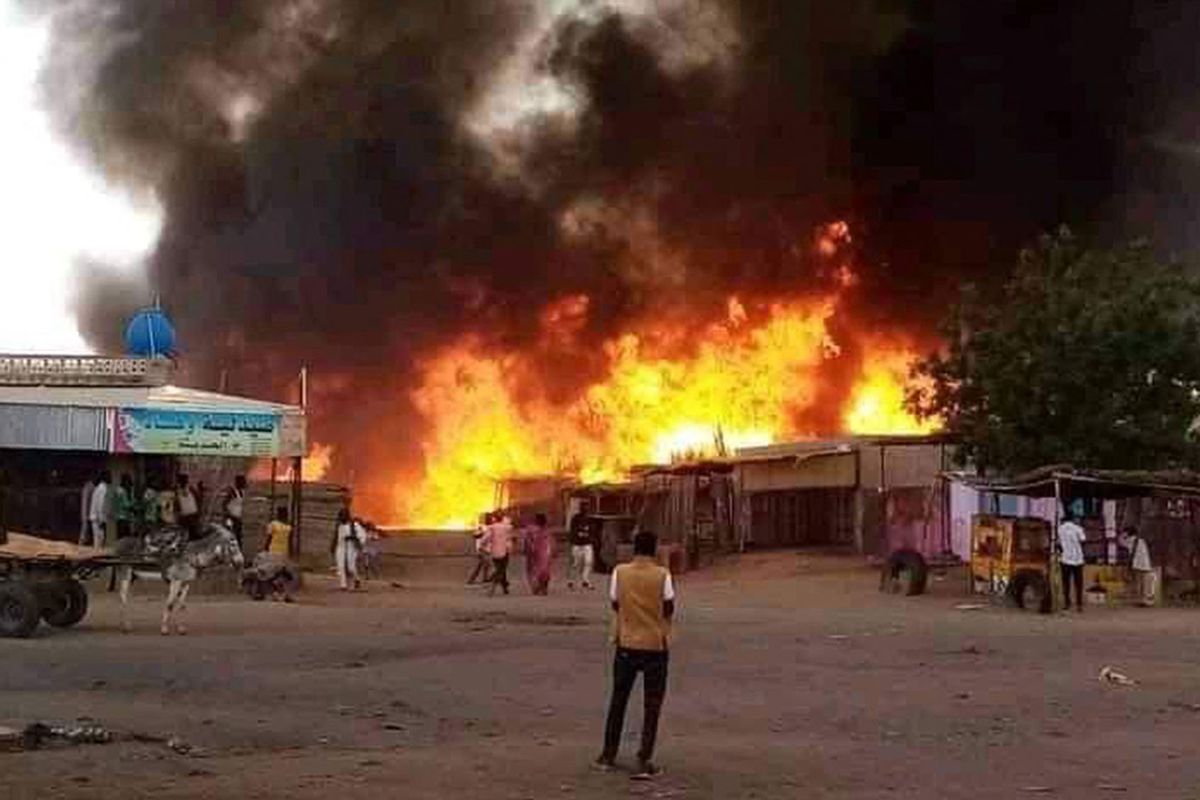 A man stands by as a fire rages in a livestock market area in al-Fasher, the capital of Sudan's North Darfur state, on September 1, 2023, in the aftermath of bombardment by the paramilitary Rapid Support Forces (RSF). (AFP via Getty Images)