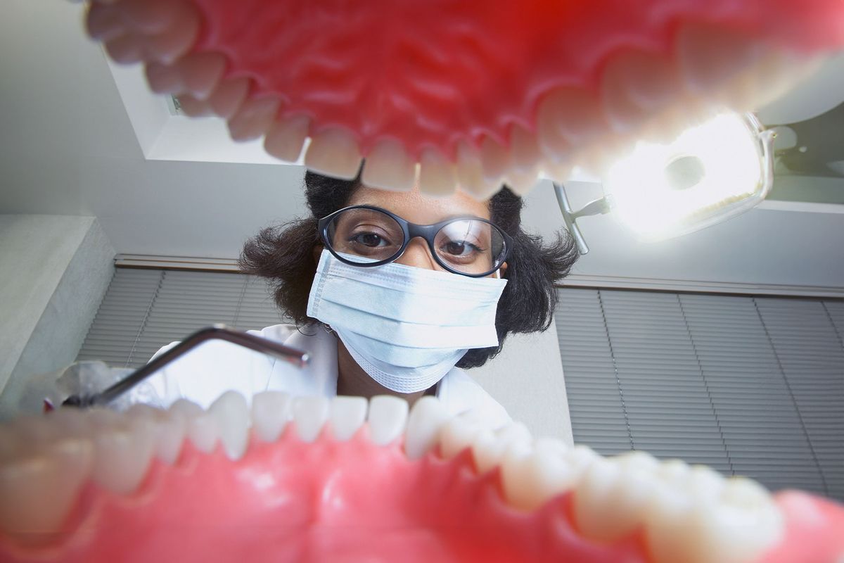 Shot from mouth looking out at dentist (Getty Images/Kris Timken)