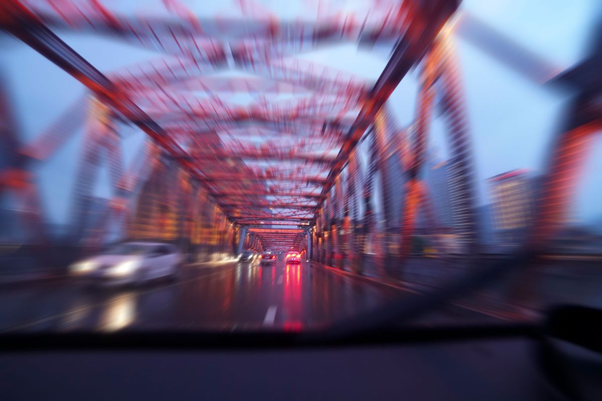 Driving a car across a bridge in the rain at night (Getty Images/Yaorusheng)
