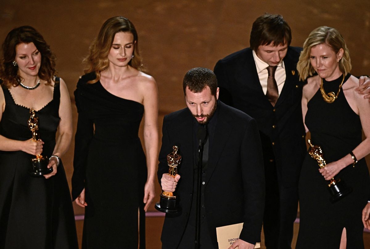 Ukrainian filmmaker Mstyslav Chernov (C), flanked by (from L) Raney Aronson-Rath, Vasilisa Stepanenko, Evgeniy Maloletka and Michelle Mizner, accepts the award for best documentary feature film for "20 Days in Mariupol" at the 96th Annual Academy Awards at the Dolby Theatre in Hollywood, California on March 10, 2024 (Patrick T. Fallon / AFP)