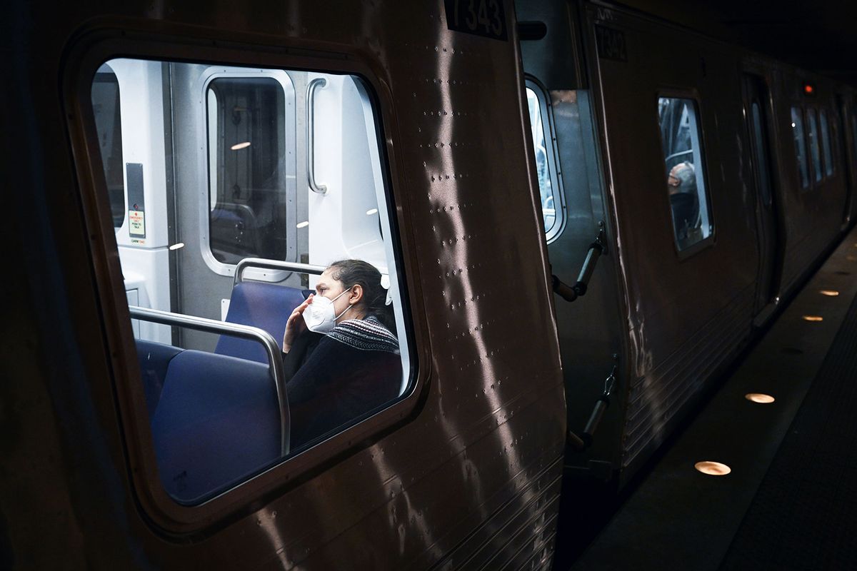 A passenger wears a mask while riding a train passing through the Metro Center station on Thursday January 04, 2024 in Washington, DC. There is currently an increase of Covid-19 cases in the United States. (Matt McClain/The Washington Post via Getty Images)