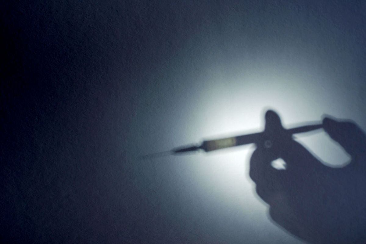 The shadow of a hand with a syringe (Getty Images/Mikhail Dmitriev)