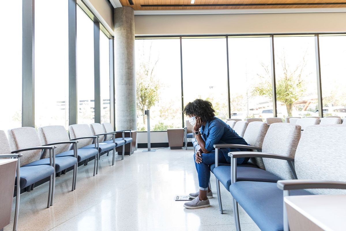 In the hospital waiting room, a woman rests her head in her hands to think. (Getty Images/SDI Productions)