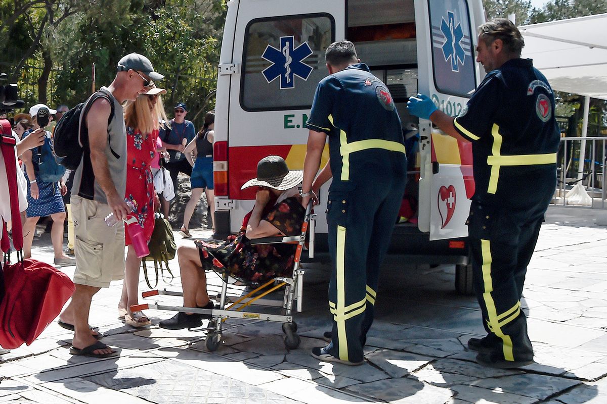 At the Acropolis ancient hill, medics help woman who has passed out from the heat during a heat wave on July 20, 2023 in Athens, Greece. (Milos Bicanski/Getty Images)
