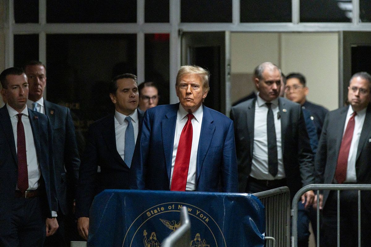 Former US President Donald Trump speaks to the press in a hallway outside the courtroom at the end of a hearing to determine the date of his trial for allegedly covering up hush money payments linked to extramarital affairs, at Manhattan Criminal Court in New York City on March 25, 2024. (JUSTIN LANE/POOL/AFP via Getty Images)