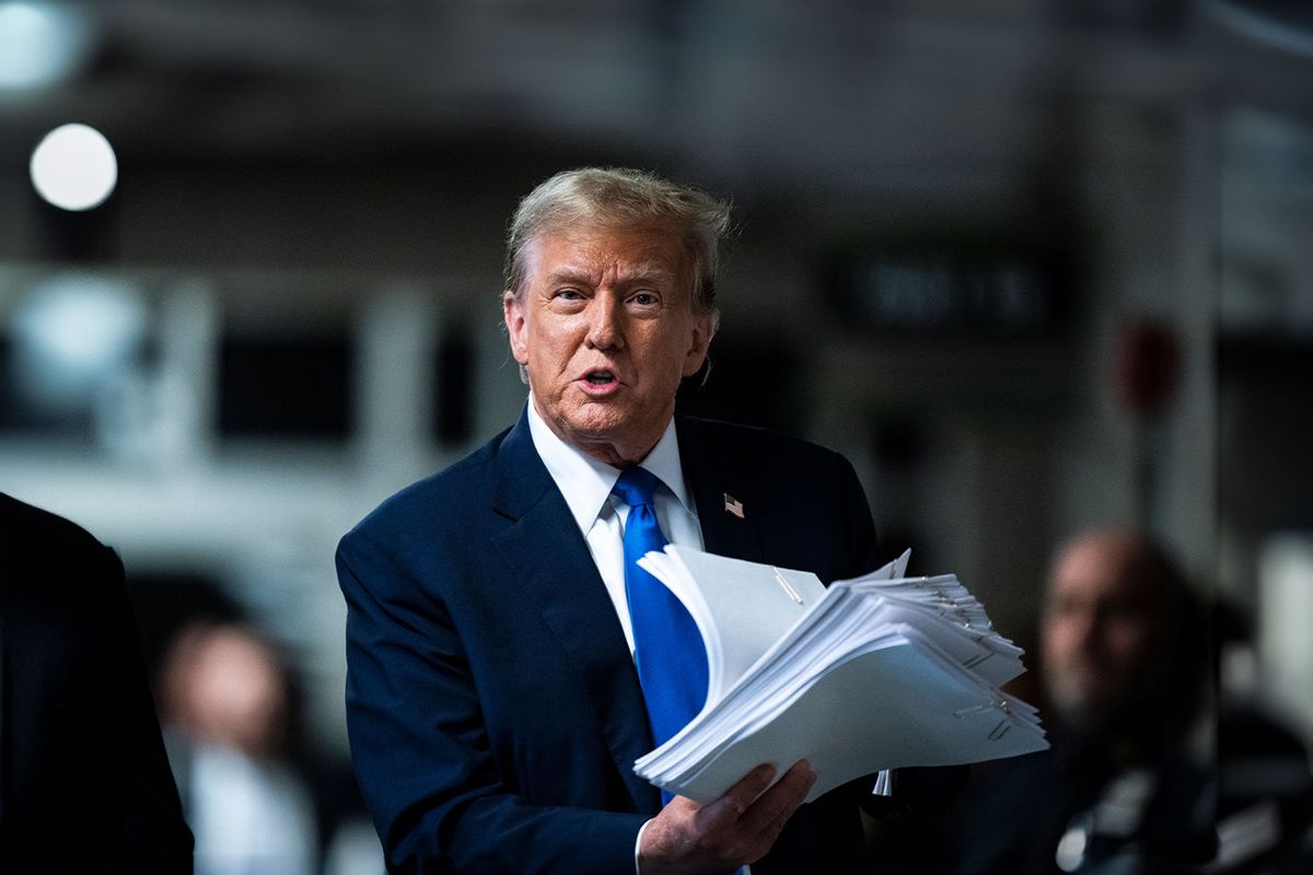 Republican presidential candidate, former President Donald Trump holds print outs of news stories as he speaks to reporters at the end of the day as jury selection continues at Manhattan Criminal Court on April 18, 2024 in New York City. (Jabin Botsford - Pool/Getty Images)