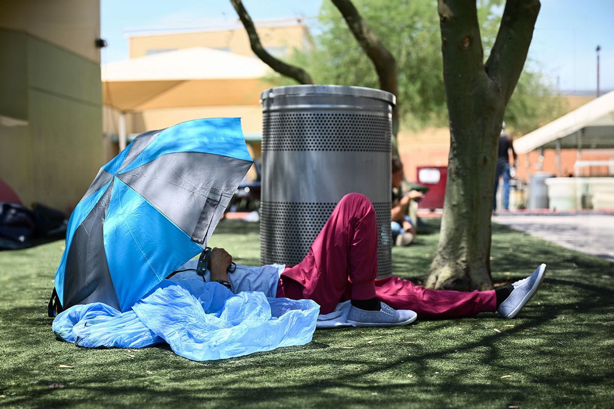 A Phoenix resident rests under shade while seeking protection from the sun and heat at the Human Services Campus during a record heat wave in Phoenix, Arizona, on July 18, 2023. (PATRICK T. FALLON/AFP via Getty Images)