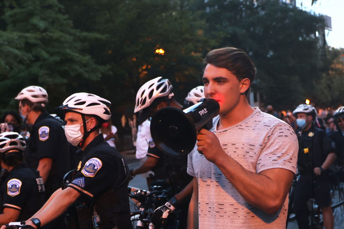 Police officers surround Jacob Wohl as he taunts protesters during a "Trump/Pence Out Now" rally at Black Lives Matter plaza August 27, 2020 in Washington, DC. (Michael M. Santiago/Getty Images)