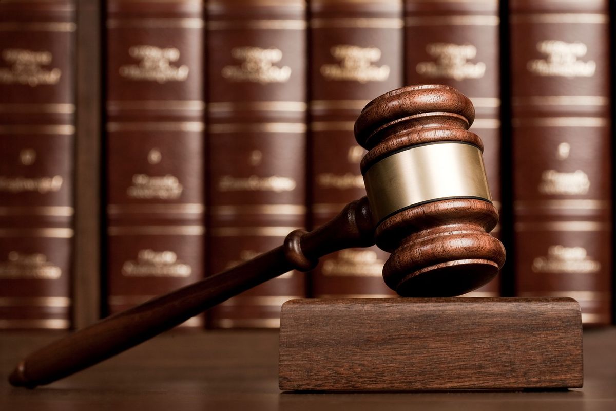 Gavel on wooden desk with books as background (Getty Images/aluxum)