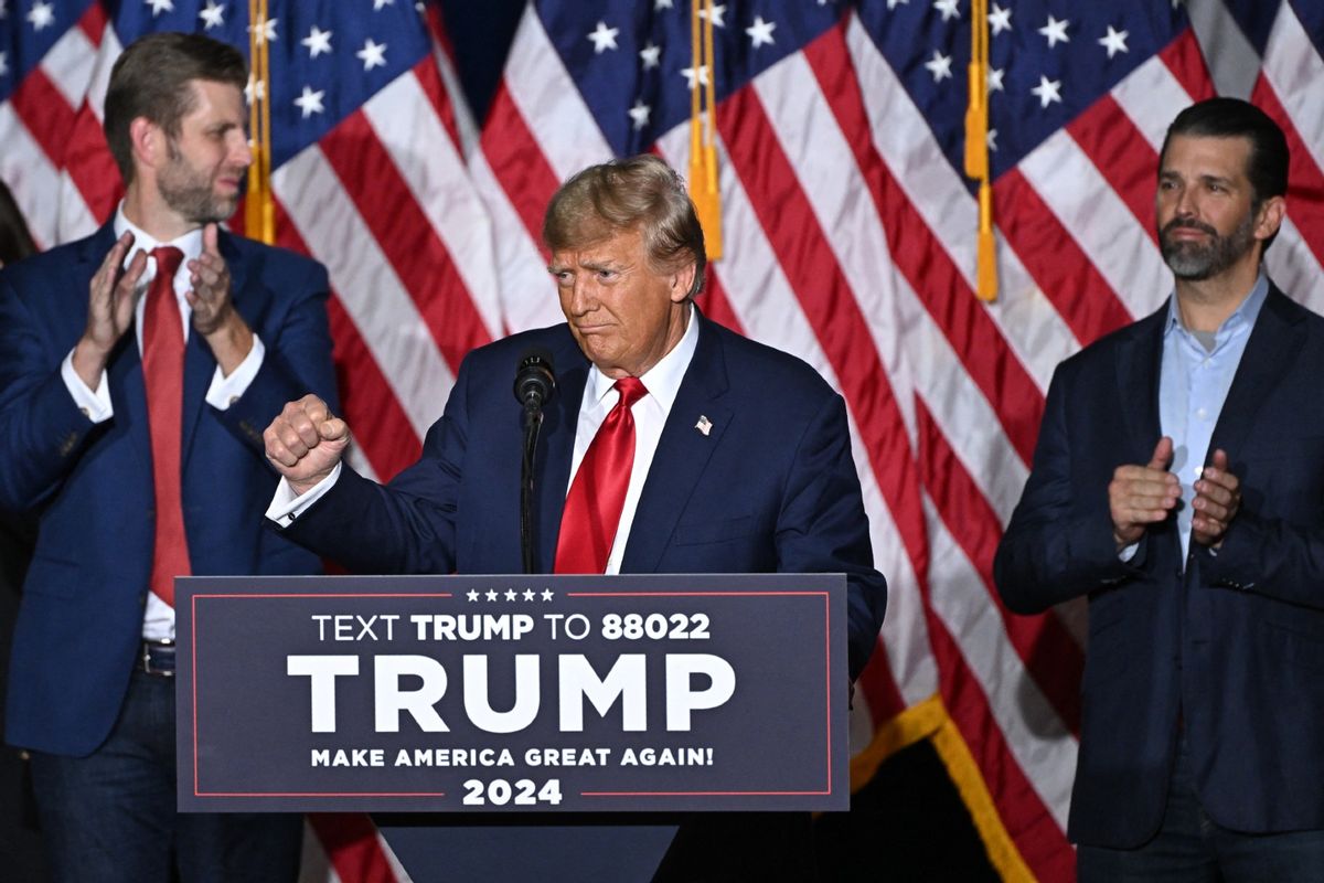 Former U.S. President and Republican presidential hopeful Donald Trump, with sons Eric (L) and Donald (R), speaks at a watch party during the 2024 Iowa Republican presidential caucuses in Des Moines, Iowa, on January 15, 2024. (JIM WATSON/AFP via Getty Images)