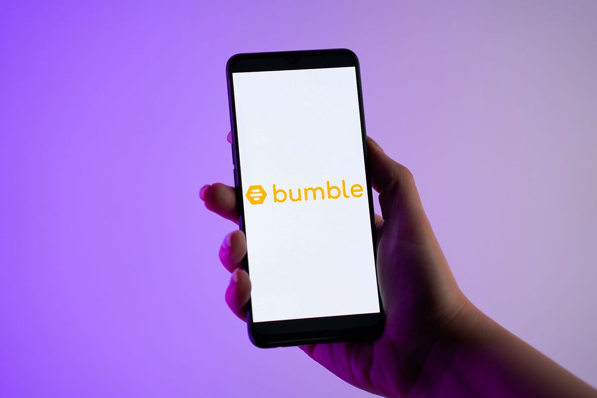 A person is holding a mobile phone with the Bumble dating app logo on its screen (Nikos Pekiaridis/NurPhoto via Getty Images)