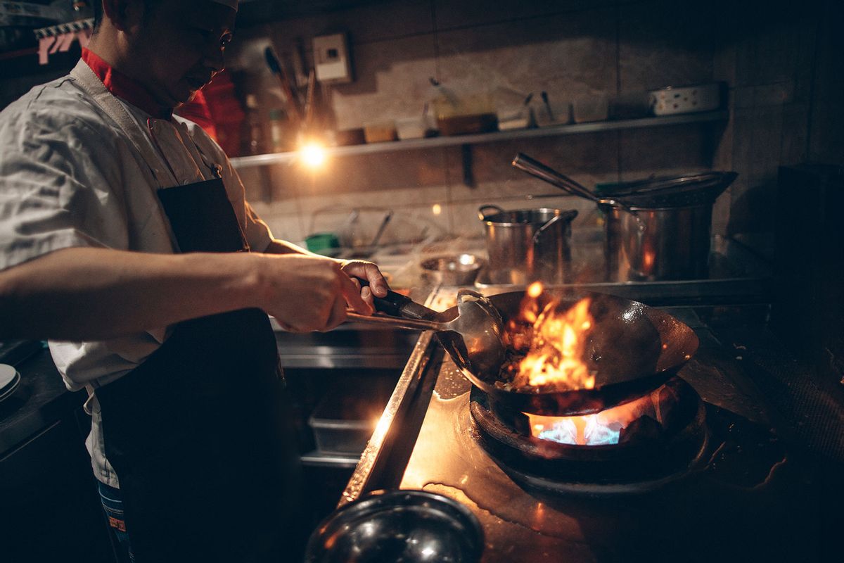 Chef preparing food in a wok (Getty Images/AleksandarNakic)