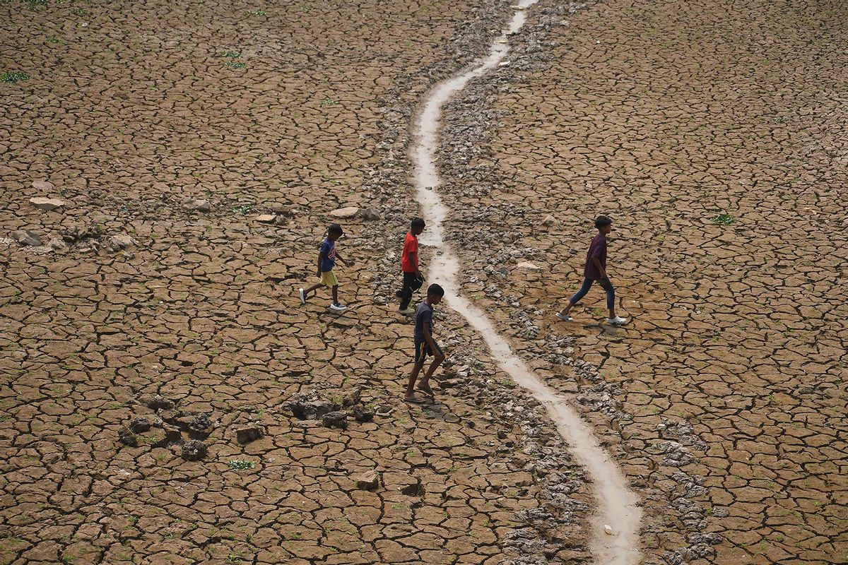 Children are crossing a dried-up lake at Boklung near Kathiatoli in Nagaon District, Assam, India, on April 13, 2024. (Anuwar Hazarika/NurPhoto via Getty Images)