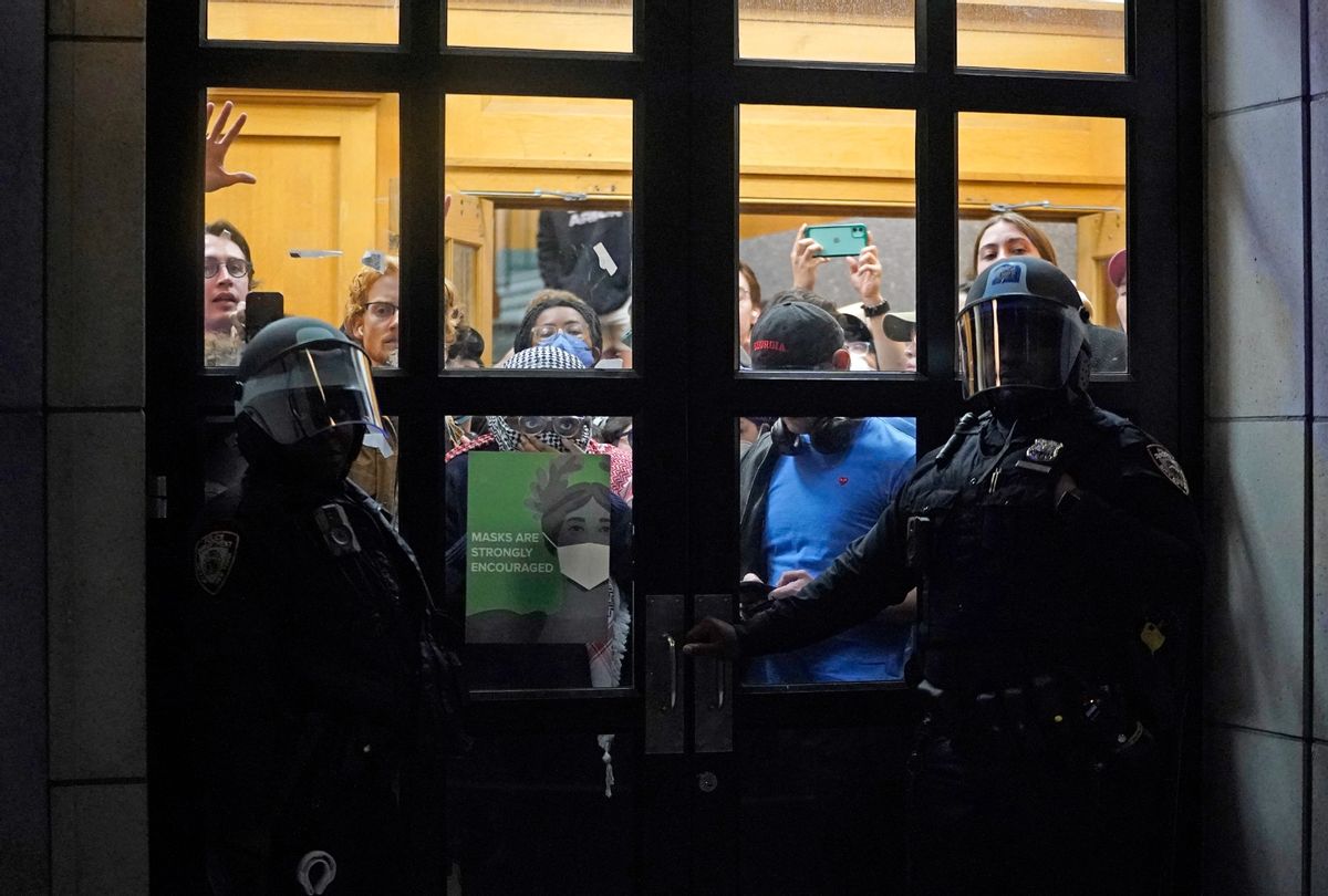 NYPD officers stand next to barricaded students at Columbia University in New York City on April 30, 2024. (TIMOTHY A. CLARY/AFP via Getty Images)