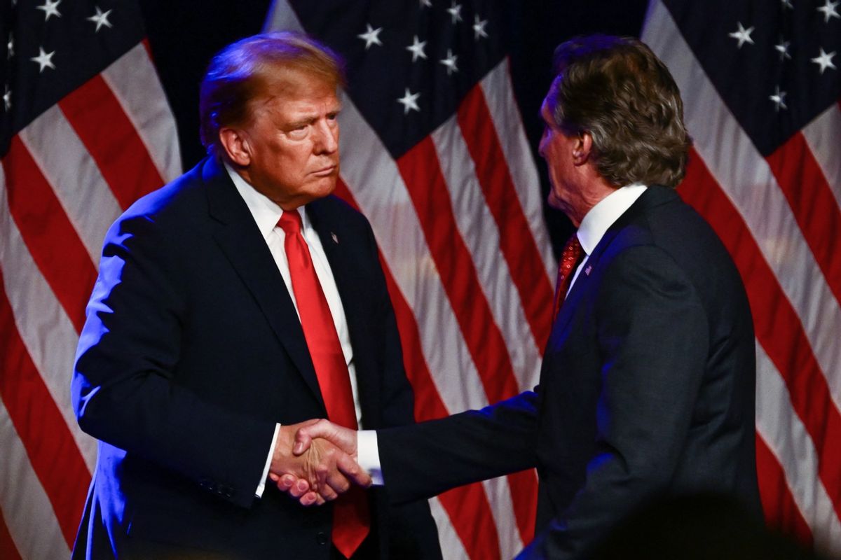Republican Governor of North Dakota Doug Burgum shakes hands with former US President and 2024 presidential hopeful Donald Trump during a Caucus Night watch party in Las Vegas, Nevada, on February 8, 2024. (PATRICK T. FALLON/AFP via Getty Images)