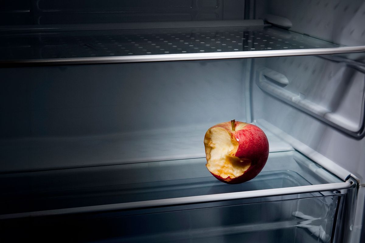 A half eaten apple in an empty refrigerator (Getty Images/Caspar Benson)