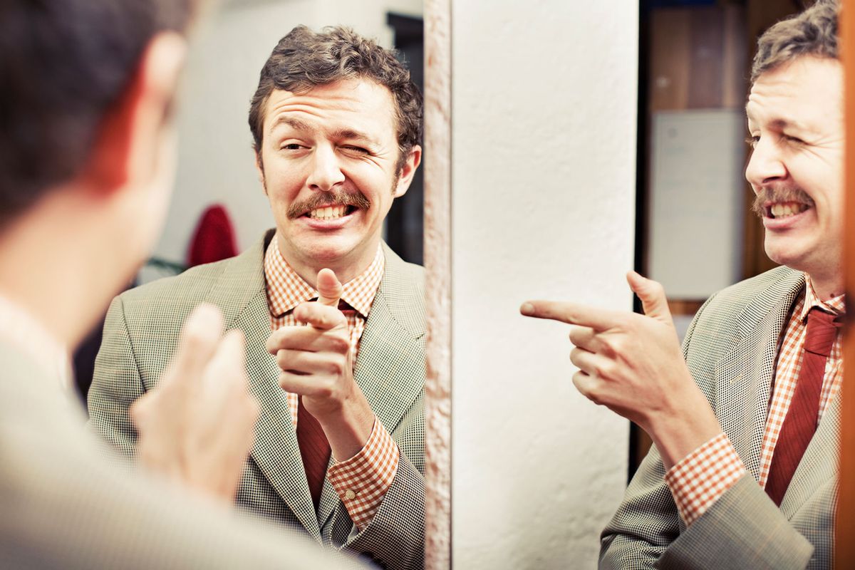Man pointing at reflection in mirror (Getty Images/Orbon Alija)