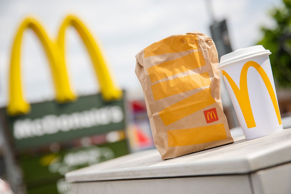 A McDonald's to-go bag and an accompanying to-go cup stand in front of a McDonald's branch (Christoph Schmidt/picture alliance via Getty Images)