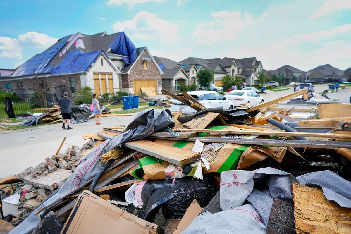 People walk through a Bridgeland neighborhood as families begin cleaning up storm damage, Sunday, May 19, 2024, in Cypress, Texas. (Brett Coomer/Houston Chronicle via Getty Images)
