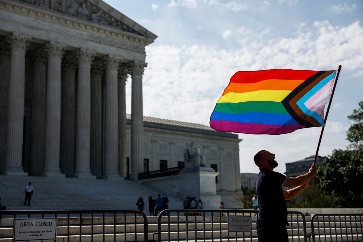 Same-sex marriage supporter Vin Testa, of Washington, DC, waves an LGBTQIA pride flag in front of the U.S. Supreme Court Building as he takes pictures with his friend Donte Gonzalez to celebrate the anniversary of the United States v. Windsor and the Obergefell v. Hodges decisions on June 26, 2023, in Washington, DC. (Anna Moneymaker/Getty Images)