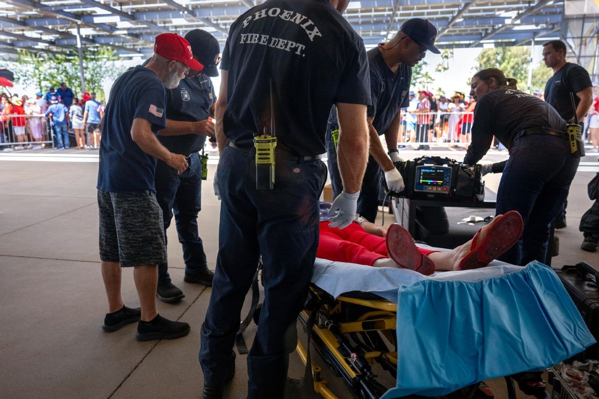 As temperatures reach 108 degrees Fahrenheit (42C), a woman is tended to for heat exhaustion as supporters line up before former U.S. President and 2024 Republican presidential candidate Donald Trump participates in a town hall event at Dream City Church in Phoenix, Arizona, on June 6, 2024.  ( JIM WATSON/AFP via Getty Images)