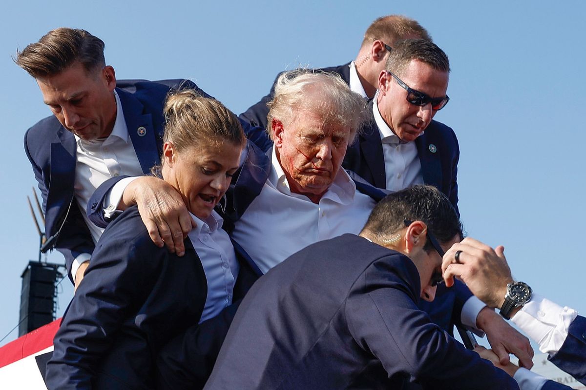 Republican presidential candidate former President Donald Trump is rushed offstage by U.S. Secret Service agents after being grazed by a bullet during a rally on July 13, 2024 in Butler, Pennsylvania. (Anna Moneymaker/Getty Images)