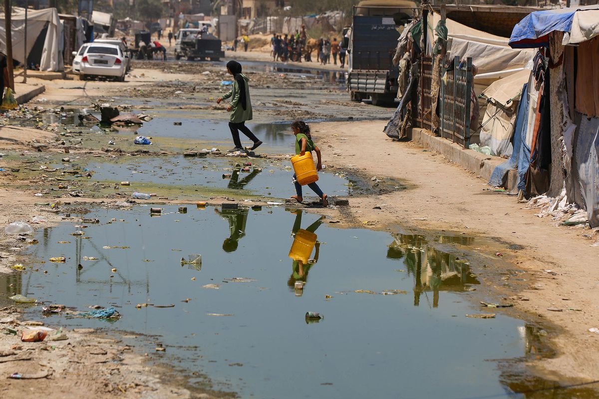 Children line up with bottles to get clean water on streets flooded with leaked sewage as the municipality announces the suspension of work in sewage treatment plants as they lack sufficient fuel due to Israel's attacks and blockade in Deir al Balah, Gaza on July 16, 2024. (Ashraf Amra/Anadolu via Getty Images)