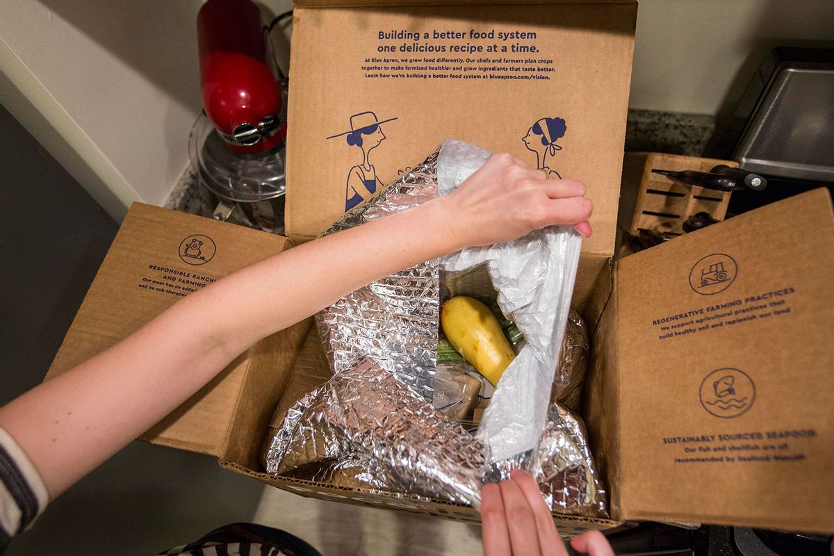 In this photo illustration, a Blue Apron customer prepares to remove items from inside a Blue Apron box on June 28, 2017 in Boston, Massachusetts. (Scott Eisen/Getty Images)