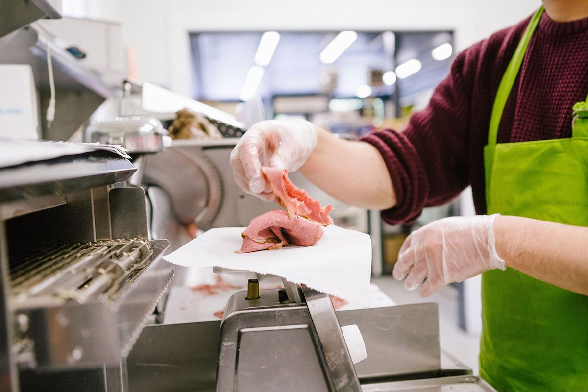 Employee in general store weighing sliced meat in kitchen (Getty Images/heshphoto)