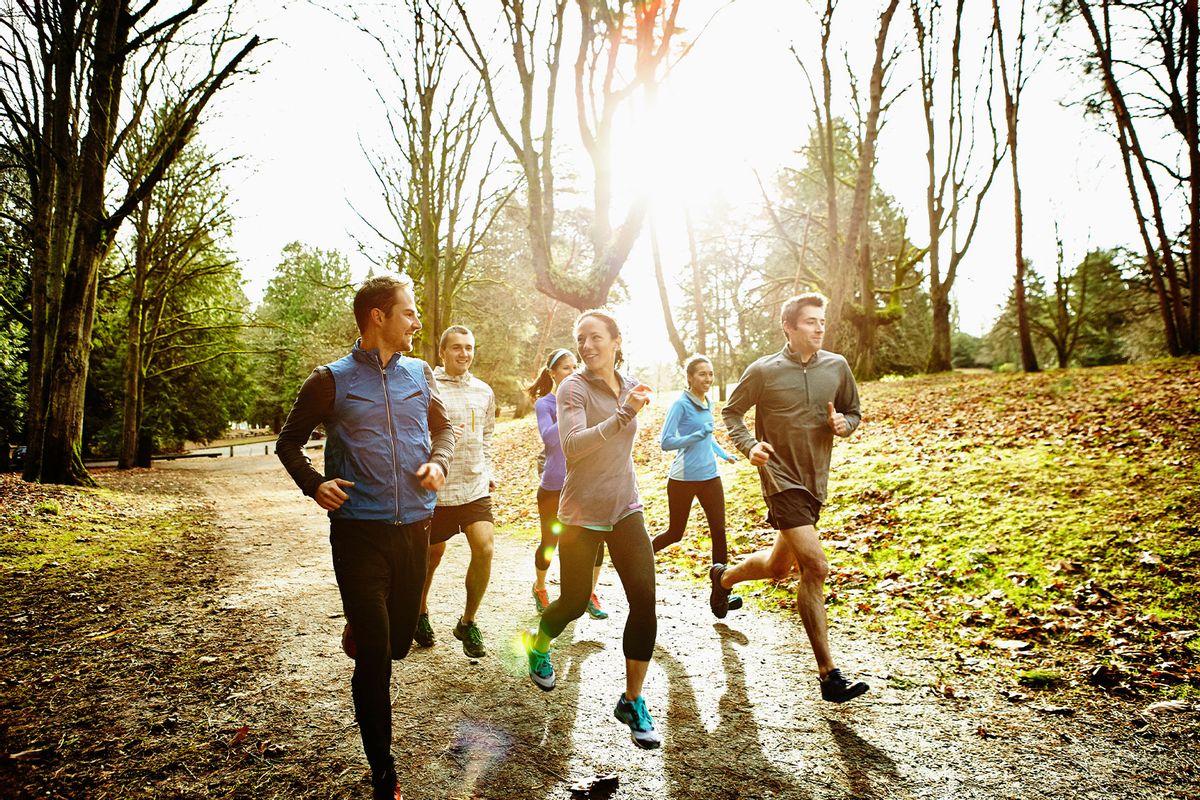 Friends running together in a park (Getty Images/Thomas Barwick)