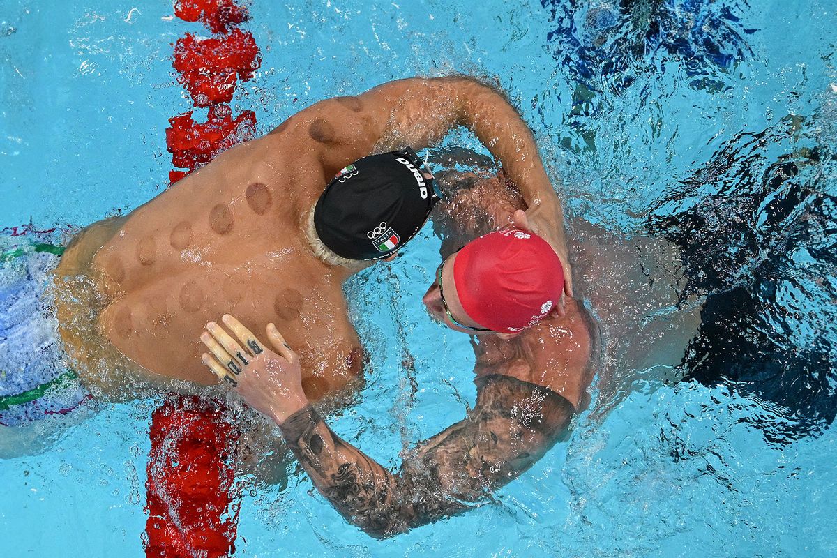 An overview shows Italy's Nicolo Martinenghi (L) celebrating with Britain's Adam Peaty (R) after winning the final of the men's 100m breaststroke swimming event during the Paris 2024 Olympic Games at the Paris La Defense Arena in Nanterre, west of Paris, on July 28, 2024. (FRANCOIS-XAVIER MARIT/AFP via Getty Images)