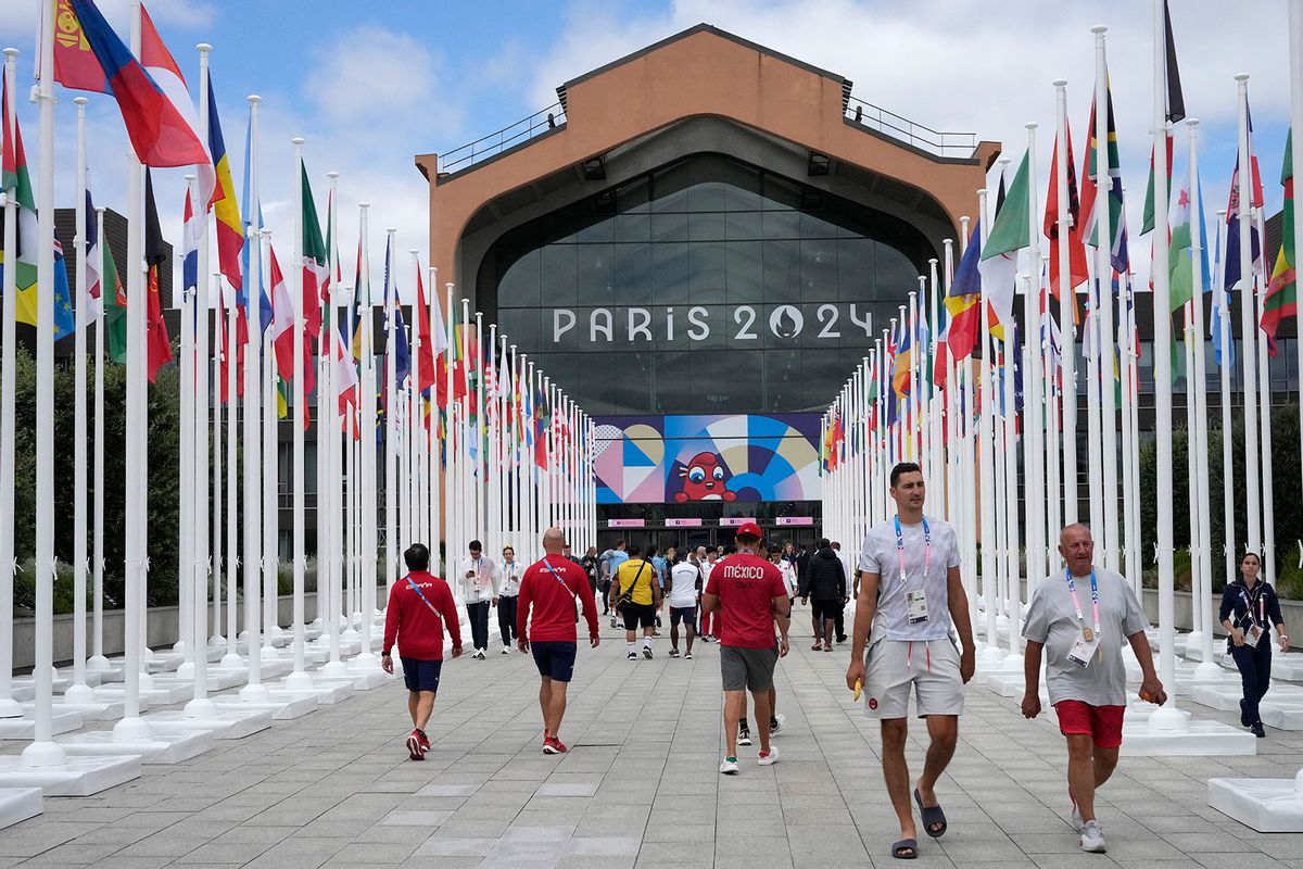 Participants of the Paris 2024 Olympics and Paralympics game walk in front of the cafeteria of the Olympic Village, in Saint-Denis, northern Paris, on July 22, 2024. (MICHEL EULER/POOL/AFP via Getty Images)