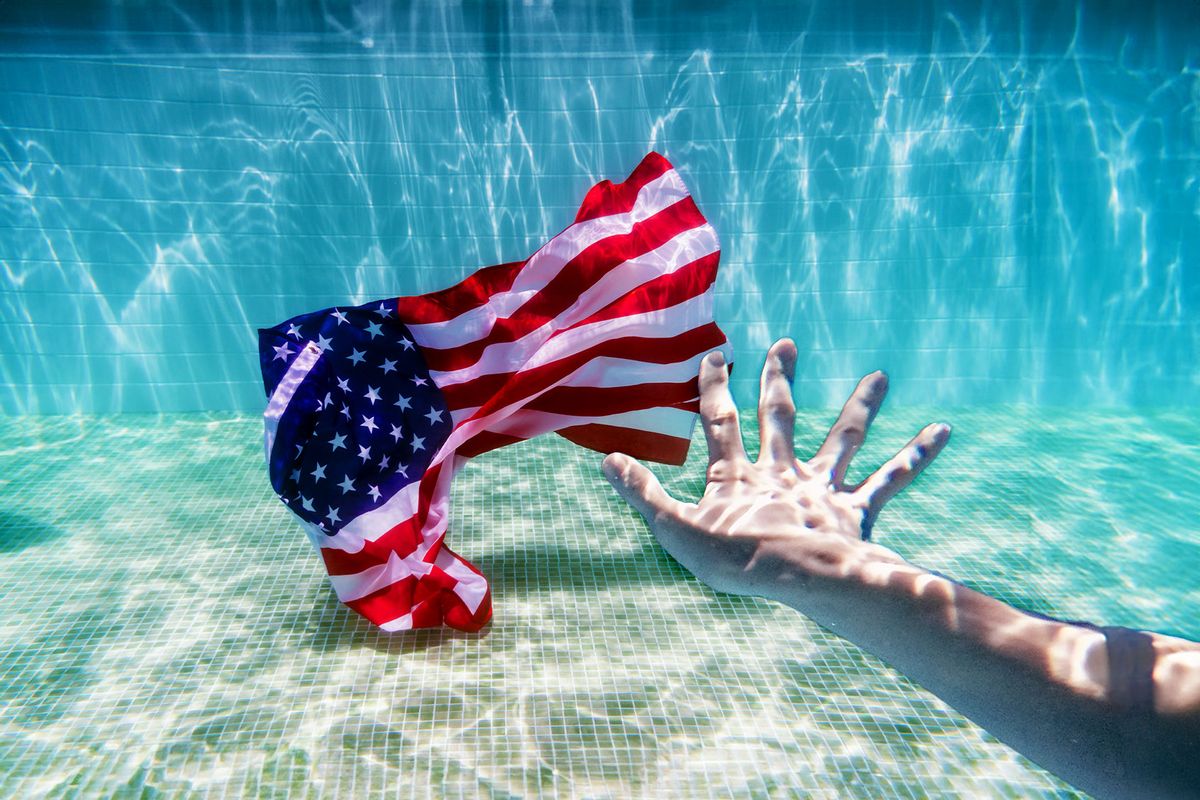 Hand reaching for American flag underwater in a pool. (Photo illustration by Salon/Getty Images)