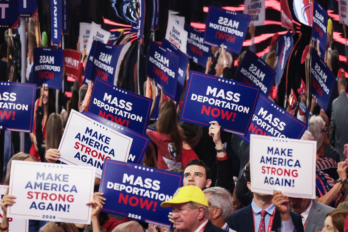 People hold signs that read "Mass Deportation Now" and "Make America Strong Again" on the third day of the Republican National Convention at the Fiserv Forum on July 17, 2024 in Milwaukee, Wisconsin. (Scott Olson/Getty Images)