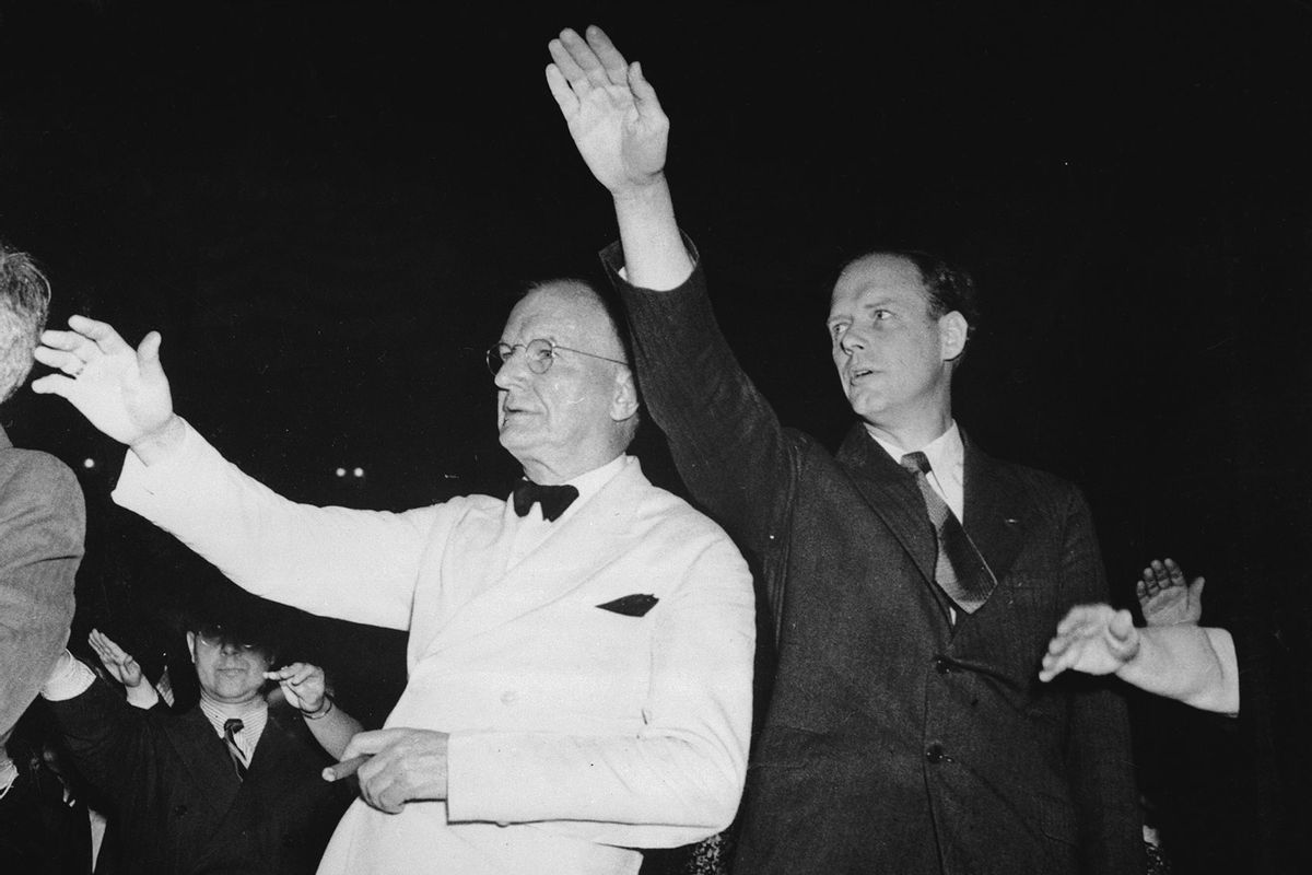 Senator Burton K. Wheeler (1882-1975, left) and Charles Lindbergh (1902-1974) pledge allegiance to the American flag at an America First Committee (AFC) rally at Madison Square Garden in New York City, 23rd May 1941. (Getty Images/Bettmann)