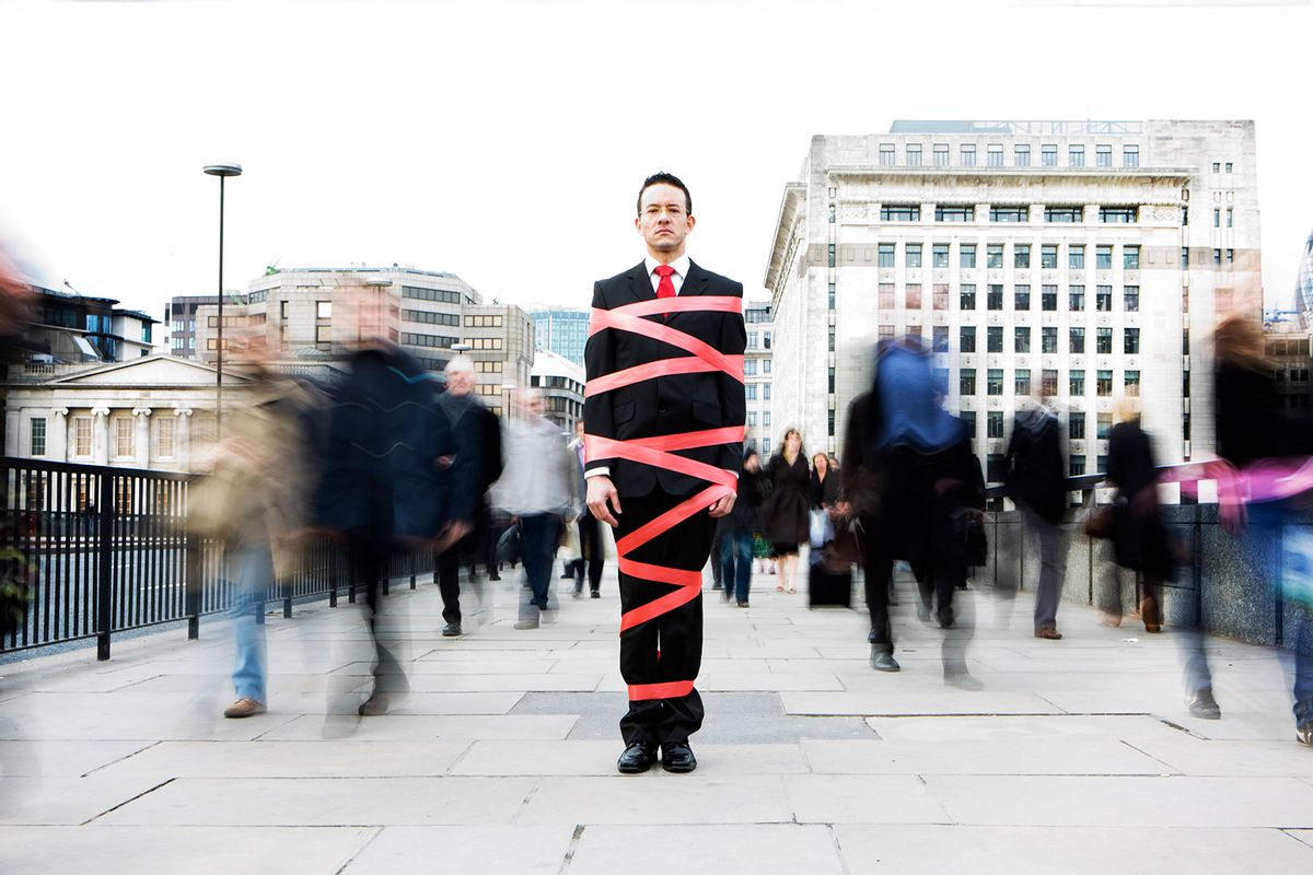 Business man tied up in bureaucracy and red tape (Getty Images/track5)