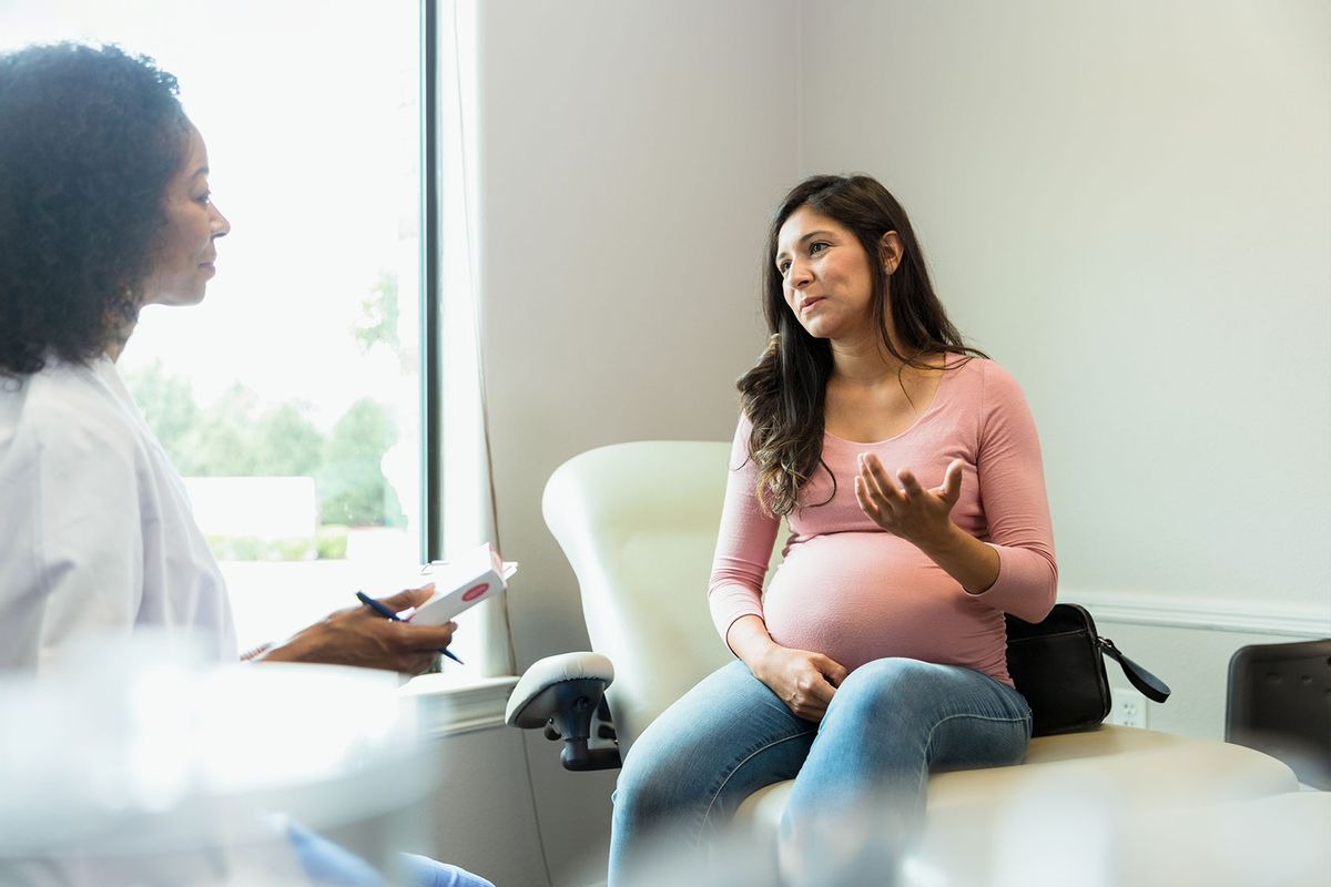 Doctor listens while pregnant patient asks about medication side effects (Getty Images/SDI Productions)