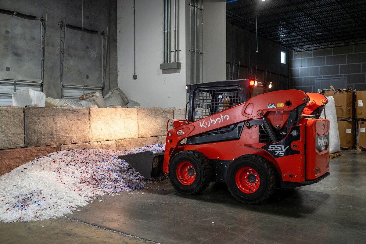 A worker loads plastic material onto a conveyer belt at ExxonMobil's chemical recycling plant on October 11, 2023, in Baytown, Texas. (SERGIO FLORES/AFP via Getty Images)