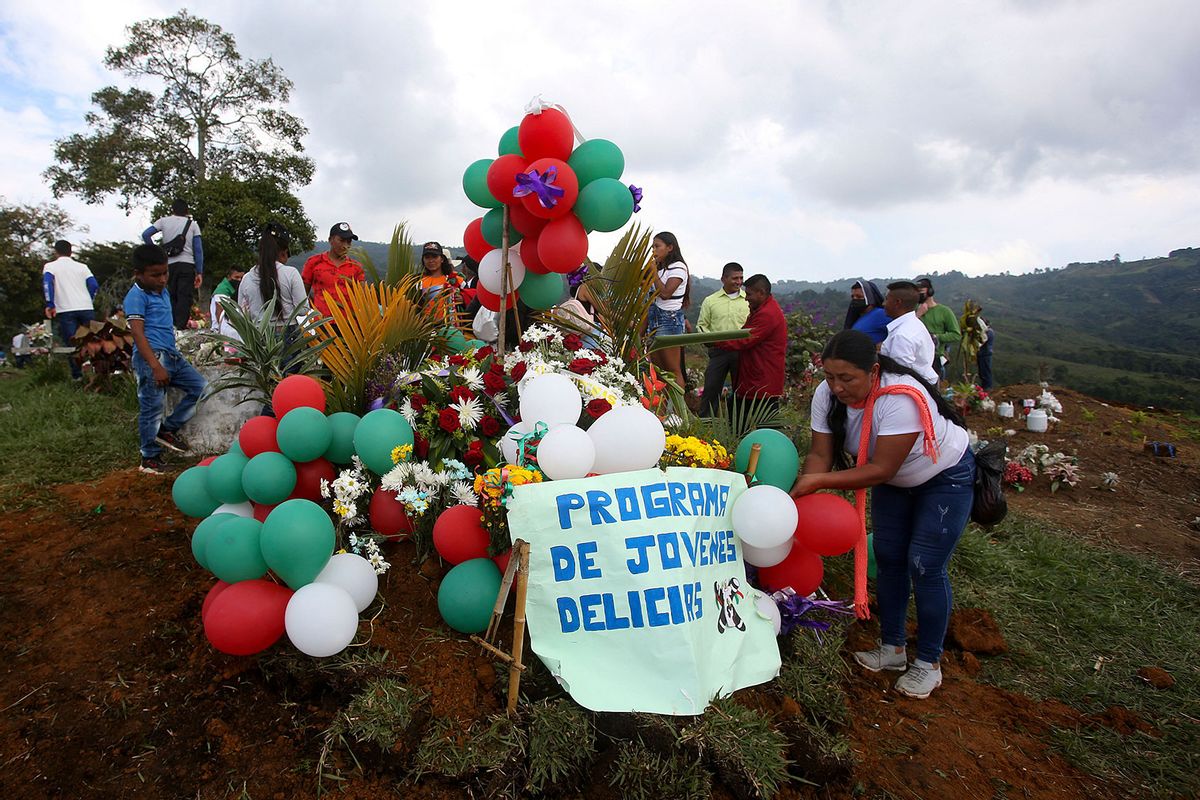 People attend the burial of Colombian 14-year-old environmental activist Breiner David Cucuname, who was shot dead during a rural security patrol on January 14, 2022, in the indigenous community of Las Delicias, Buenos Aires municipality, in the Colombian southwestern Cauca Department, on January 17 , 2022. (STR/AFP via Getty Images)