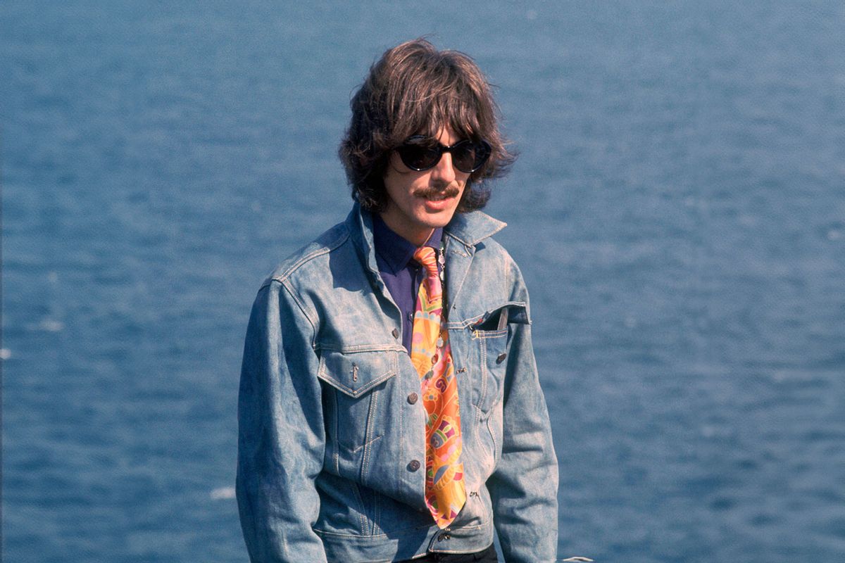 George Harrison of English rock and pop group The Beatles, wearing sunglasses and a denim jacket, takes part in filming of the television musical film 'Magical Mystery Tour' at Newquay in Cornwall on 13th September 1967. (David Redfern/Redferns/Getty Images)