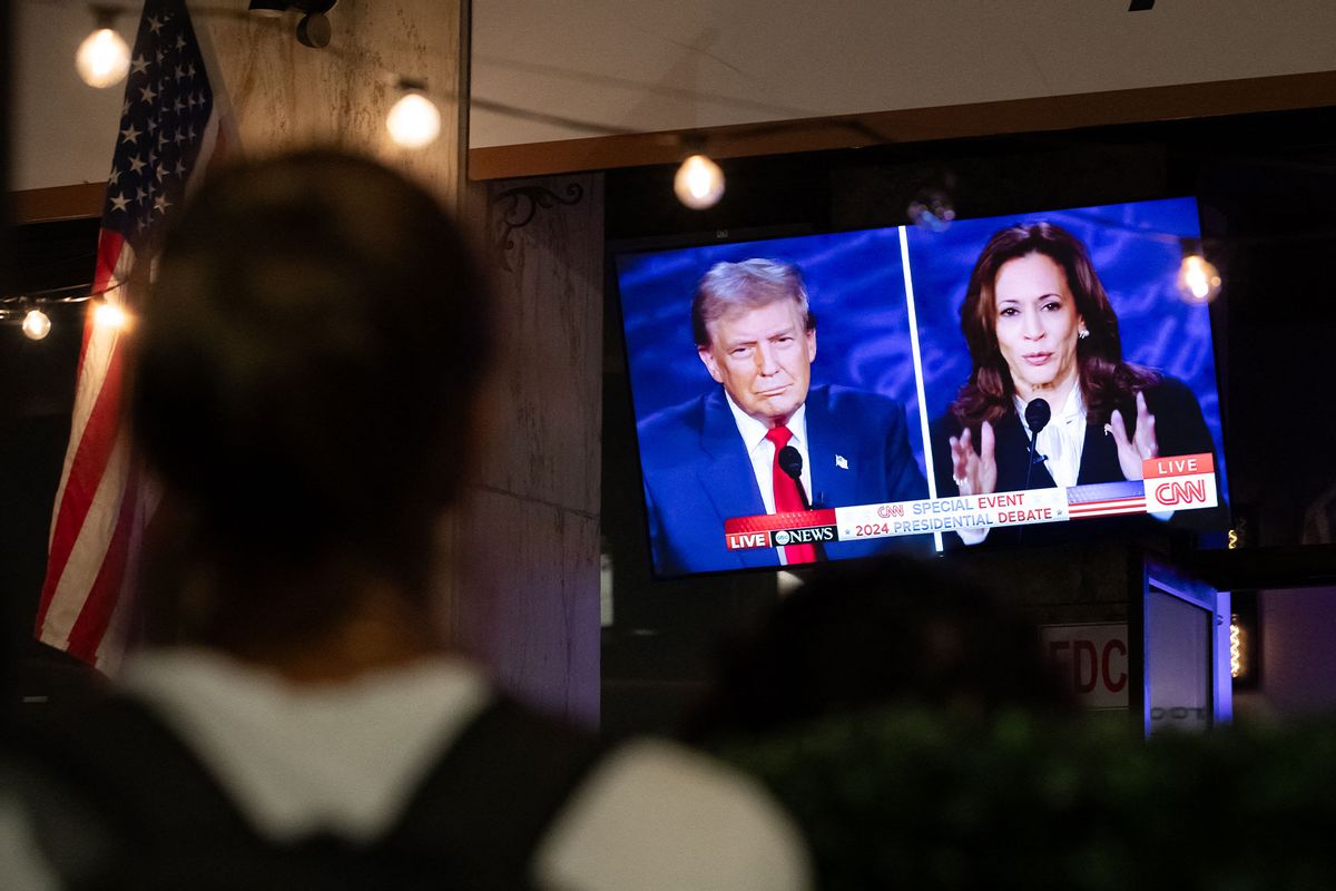 A walking patron stops to watch a screen displaying the US Presidential debate between Vice President and Democratic presidential candidate Kamala Harris and former US President and Republican presidential candidate Donald Trump at The Admiral in Washington, DC, on September 10, 2024. (ALLISON BAILEY/AFP via Getty Images)