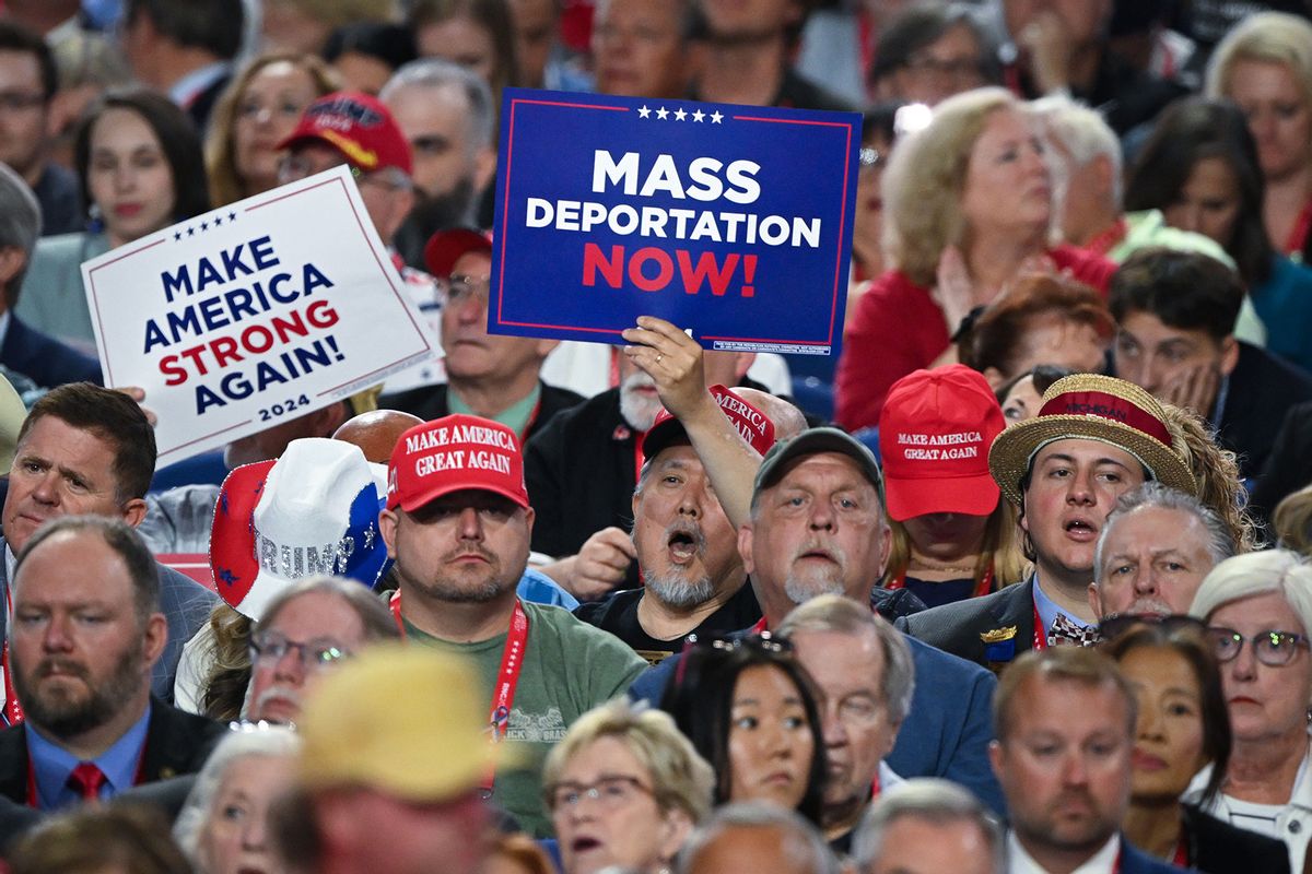 A person holds a sign that reads "Mass Deportation Now" and "Make America Strong Again" on the third day of the Republican National Convention at the Fiserv Forum on July 17, 2024 in Milwaukee, Wisconsin. (Leon Neal/Getty Images)