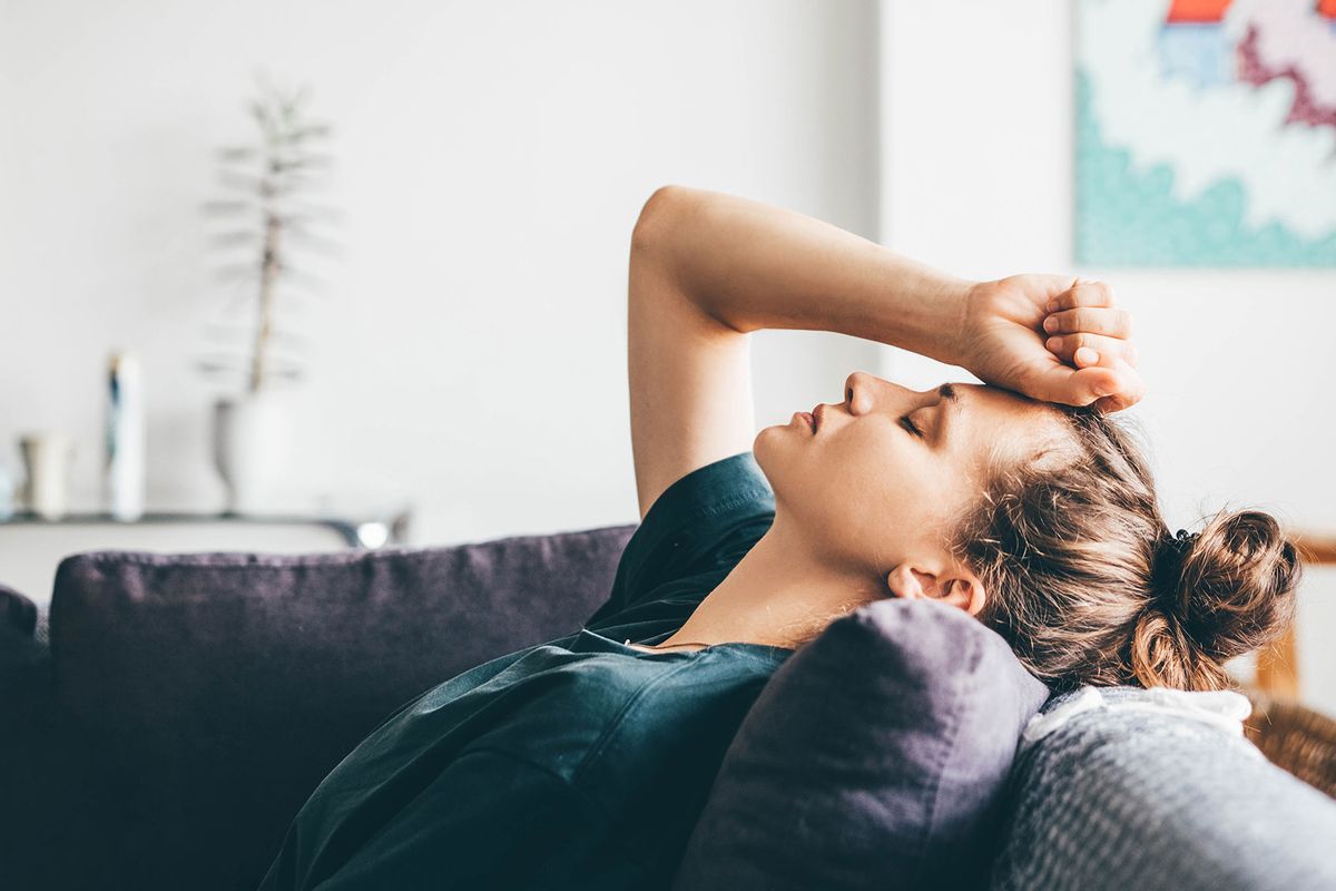 Sad and depressed woman sitting on sofa at home. (Getty Images/Maria Korneeva)